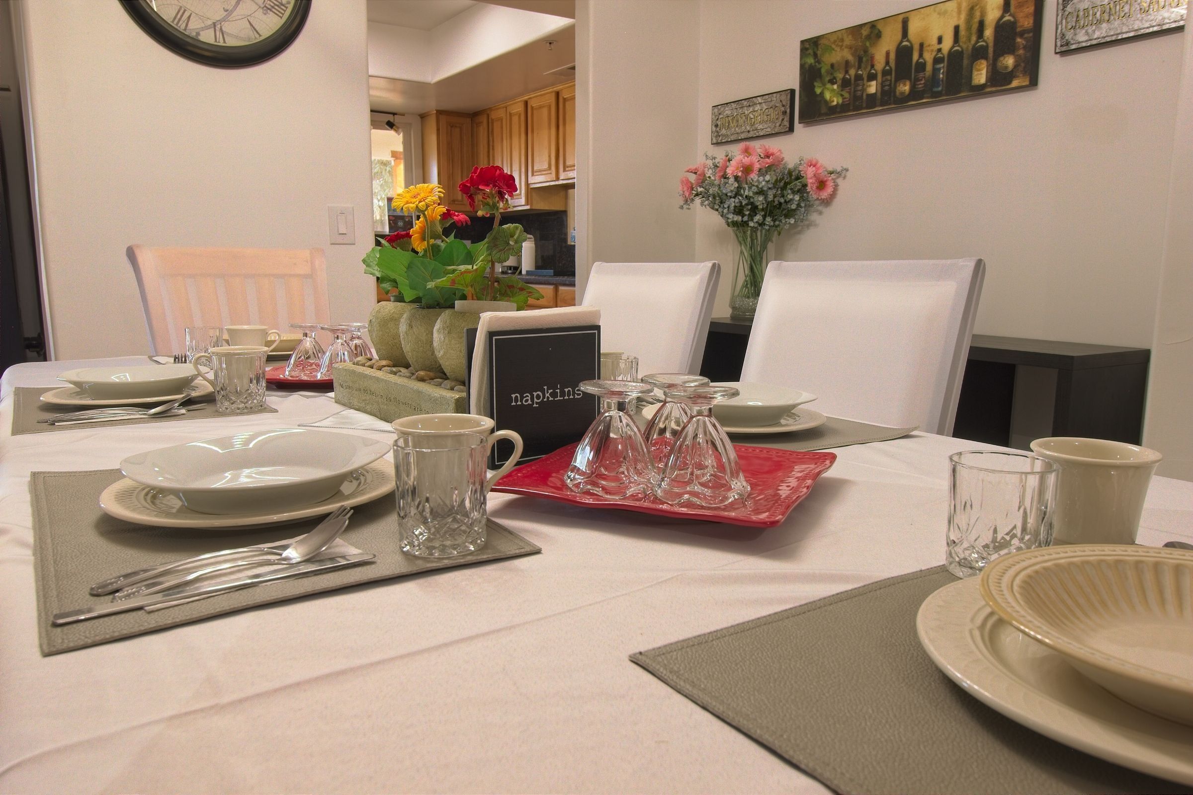 Place settings on the dining table, with fresh flowers